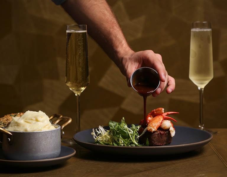 Pouring sauce over entree